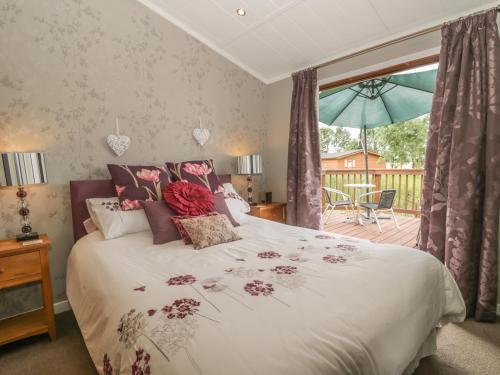 a bedroom with a large bed with flowers on it at Bulmer Farm Lodge in Malton