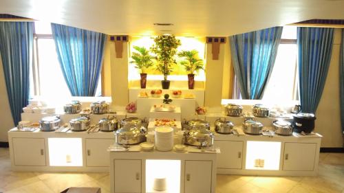 a room with pots and pans on tables with blue curtains at Royal Fort Hotel in Visakhapatnam