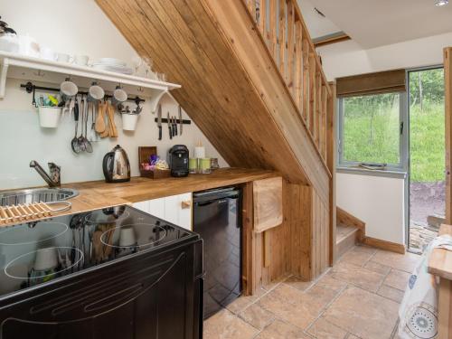 a kitchen with wooden walls and a staircase at Kidcleugh Hide in Duns
