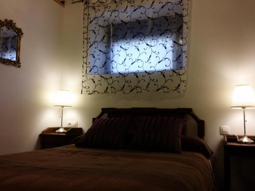 een slaapkamer met een bed met 2 lampen en een raam bij Casa Rural Villamoronta in La Rad