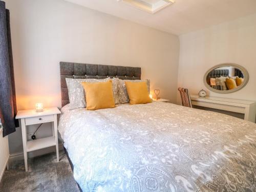 une chambre avec un grand lit et un miroir dans l'établissement End cottage, à Ashbourne