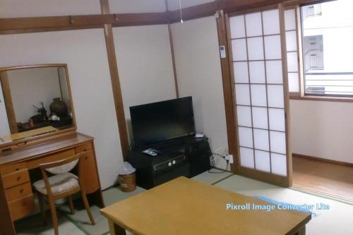奈良市にあるお宿 芳かわのテレビ、デスク、鏡が備わる客室です。