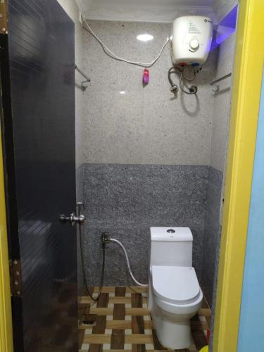 a bathroom with a toilet and a camera on the wall at Gayathri Stay in Kanchipuram