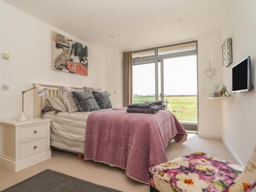 sypialnia z łóżkiem i dużym oknem w obiekcie 8 Cribbar w Newquay
