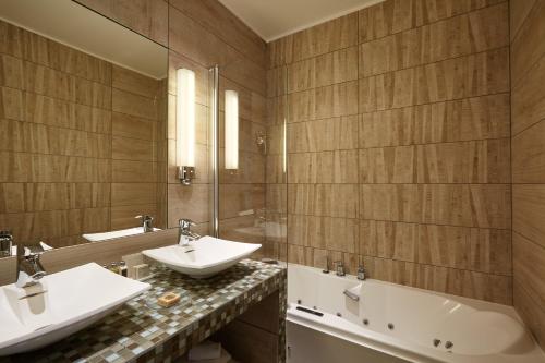 巴黎的住宿－聖雅克驛站酒店，浴室配有2个盥洗盆和1个浴缸。