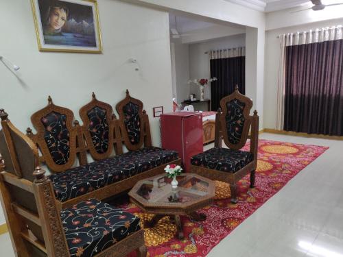 a living room with chairs and a couch and a table at Chandra Inn in Jodhpur