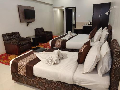 a hotel room with two beds and a television at Chandra Inn in Jodhpur