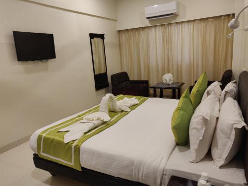 een slaapkamer met een groot bed en een tv aan de muur bij Chandra Inn in Jodhpur