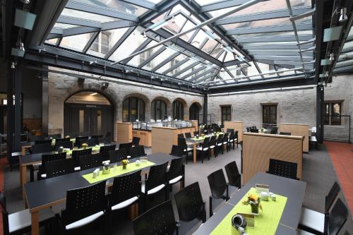 a dining room with tables and chairs and windows at Gästehaus Nikolai in Erfurt