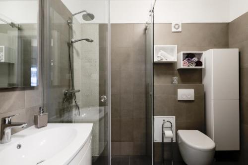 a bathroom with a shower and a sink and a toilet at Donatus - Modern apartment near the bridge/centre in Zadar