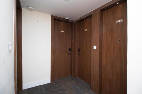 a hallway with two wooden doors in a room at Hotel Vagmi in Varanasi