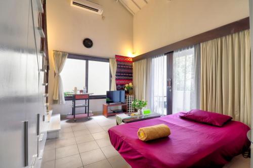 沙努爾的住宿－沙努爾ABC公寓，一间带粉红色床的卧室和一间客厅