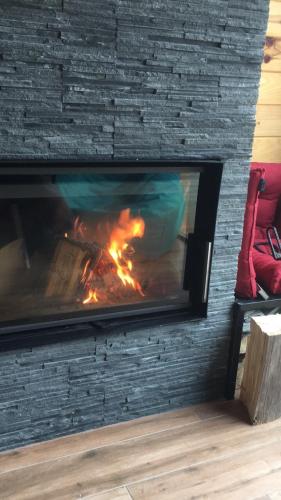 a fireplace with a fire in it next to a brick wall at Zaovinska idila in Bjeluša