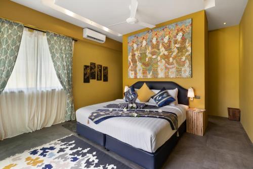 a bedroom with a bed and a painting on the wall at Baan Putahracsa in Laem Sor