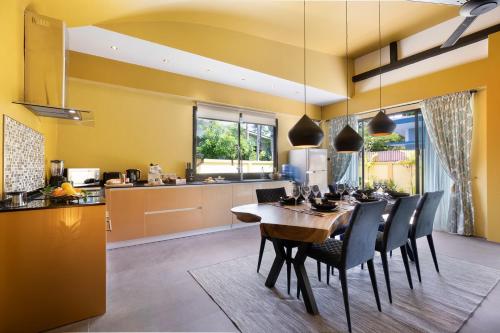 a kitchen and dining room with a table and chairs at Baan Putahracsa in Laem Sor
