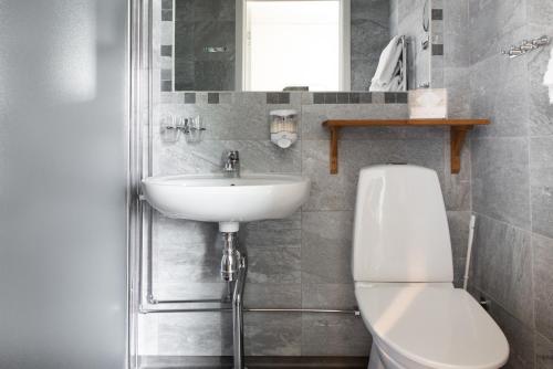 uma casa de banho com um WC branco e um lavatório. em Balingsholm em Huddinge