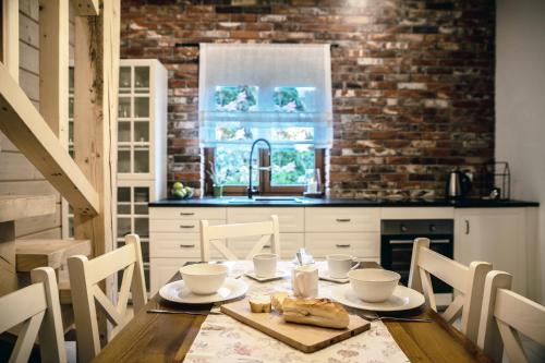 una cucina con tavolo in legno, sedie e un angolo cottura. di Domek u Bronka a Białka