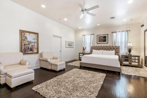 een witte slaapkamer met een bed en 2 stoelen bij Spacious 4BD Luxury Penthouse with Balcony in New Orleans