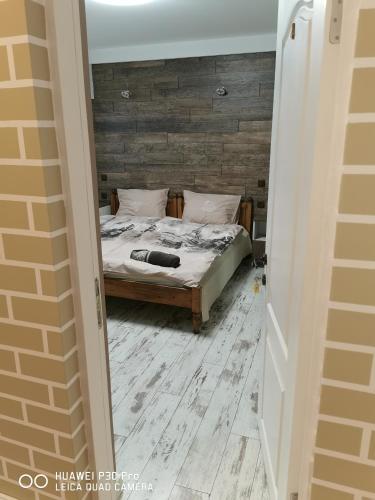 a bedroom with a bed with a wooden wall at Hotel Belisimo in Ruse