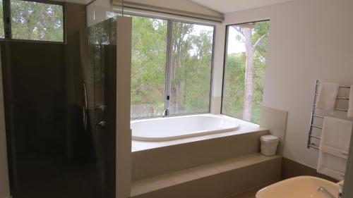 y baño con bañera y ventana. en Vintners - more space for you to enjoy! en Quindalup
