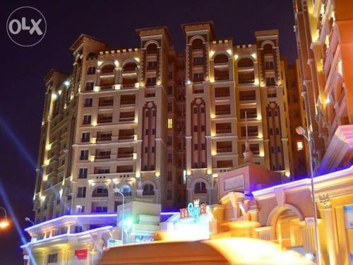 a large building is lit up at night at Alexandria princess in Alexandria