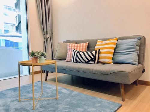 a living room with a couch with pillows and a table at The Wave Suites Melaka in Melaka