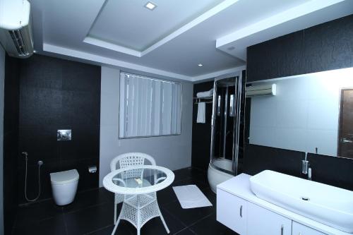 baño con lavabo blanco y mesa blanca en Royal Castle Hotel, en Negombo