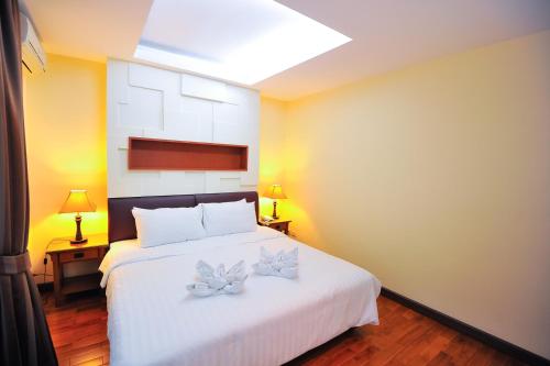 a bedroom with a white bed with two butterflies on it at 42Grand Residence in Bangkok
