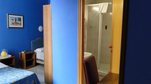 um quarto azul com um chuveiro e um quarto em Hotel Altavilla Dieci em Roma