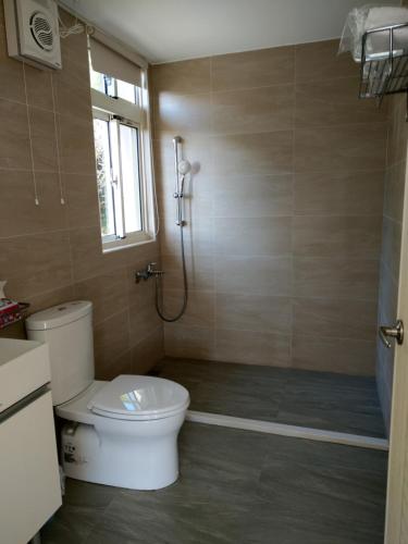 a bathroom with a toilet and a shower at Shan Hu Lian Homestay in Zhuolan