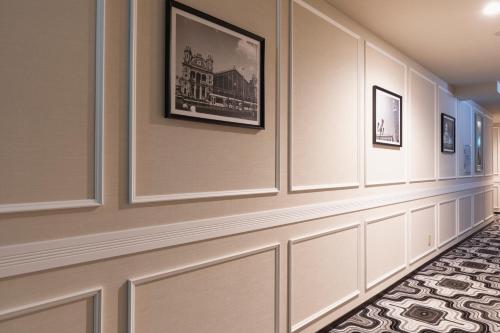 a hallway with pictures on the wall and a carpet at Centurion Hotel & Spa Kurashiki Station in Kurashiki