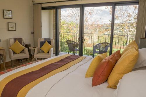 a bedroom with a large bed and a balcony at Vineyard Barn Room in Stroud