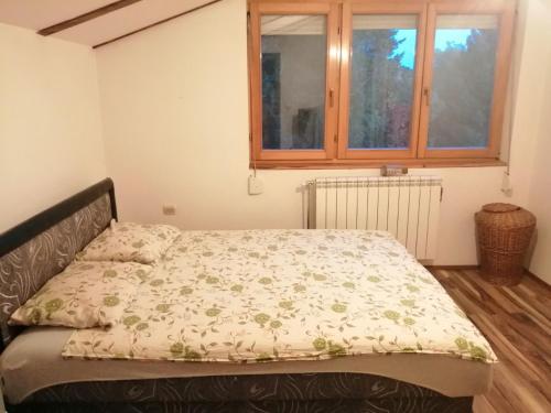 Bett in einem Zimmer mit Fenster in der Unterkunft Apartment Viktor in Belgrad
