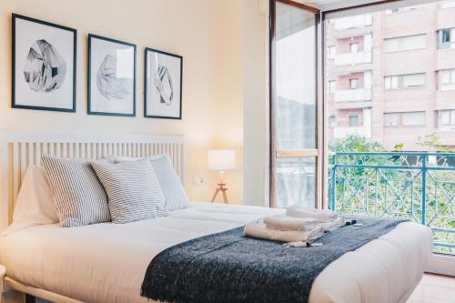 um quarto com uma cama e uma grande janela em Sani apartment by People Rentals em Bilbao