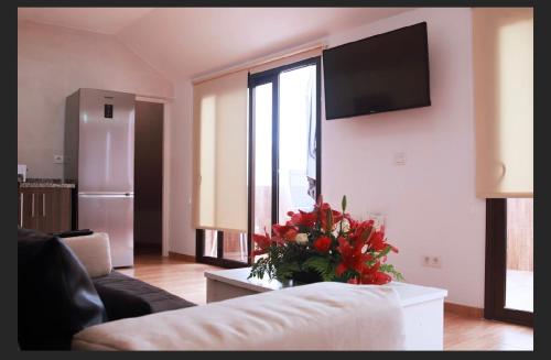 uma sala de estar com um sofá e um vaso de flores em Apartamento Germán em Garachico