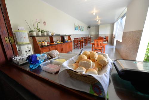 a table with a basket of bread on top of it at Pousada do Gunga in Barra de São Miguel