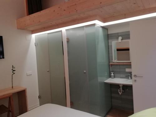 a bathroom with glass cabinets and a sink at Hotel Rural Aguazul in Covanera