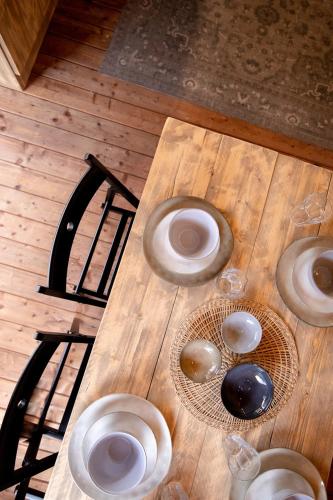 a wooden table with plates and wine glasses on it at Glamping Can Bora Lodges in Las Serras