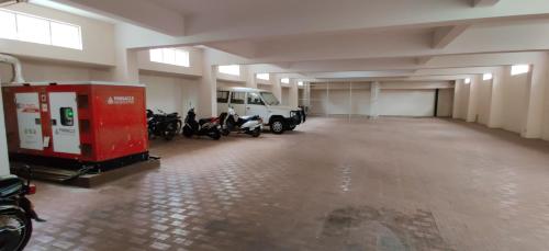 a garage with motorcycles and a white van in it at Suvarna Suits in Mysore