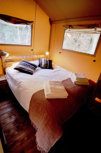 a bedroom with a large bed with towels on it at Glamping Can Bora Lodges in Las Serras