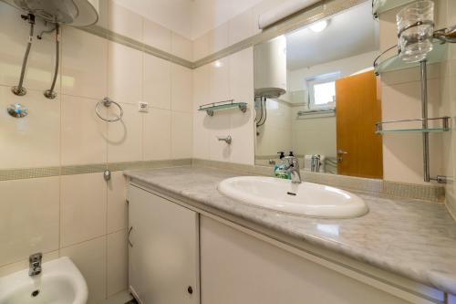 a bathroom with a sink and a mirror at Apartments Nada in Baška