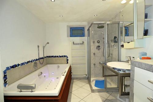 uma casa de banho com uma banheira, um chuveiro e um lavatório. em Mariposa Apartamento em Efringen-Kirchen