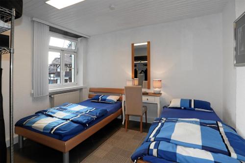a bedroom with two beds and a desk and a window at Mariposa Apartamento in Efringen-Kirchen