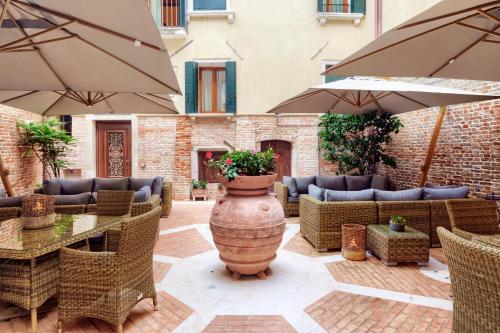 an outdoor patio with tables and chairs and umbrellas at Hotel Bisanzio in Venice