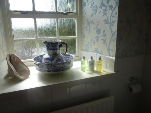 a window sill with a vase and bottles on it at The Gin Gan in Hexham