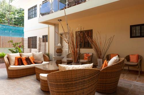 a living room with wicker furniture and a pool at Chez Bea Luxury Villa in Baie Sainte Anne