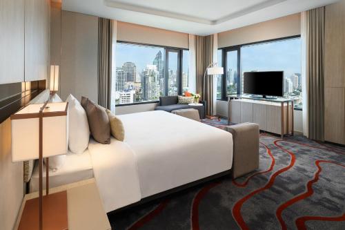 a hotel room with a large bed and a large window at Hotel Nikko Bangkok in Bangkok