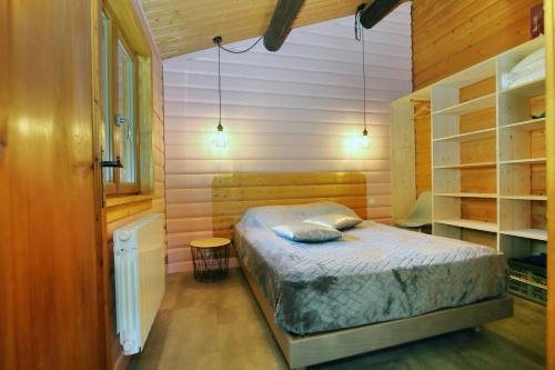 - une chambre avec un lit dans une pièce dotée d'étagères dans l'établissement COCOONING, à Gérardmer