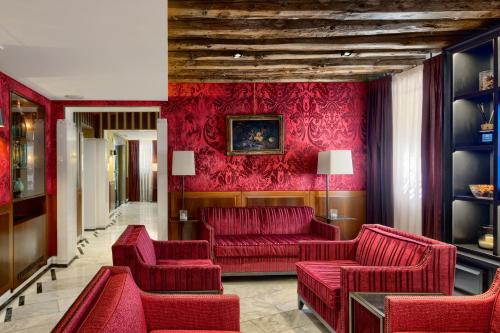 uma sala de estar com mobiliário vermelho e paredes vermelhas em Hotel Bisanzio em Veneza