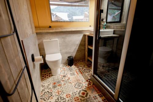 a bathroom with a toilet and a sink at Glamping Can Bora Lodges in Las Serras